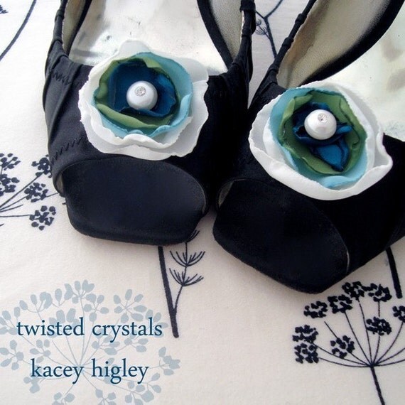 A pair of handmade innocent ivory and something blue flowers filled with a large fresh water pearl and Swarovski crystal. For your wedding, favorite shoes and life.
