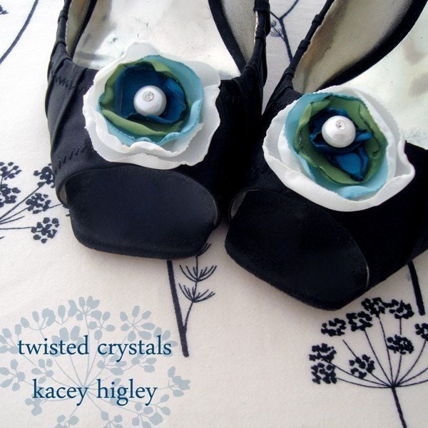 A pair of handmade innocent ivory and something blue flowers filled with a large fresh water pearl and Swarovski crystal. For your wedding, favorite shoes and life.
