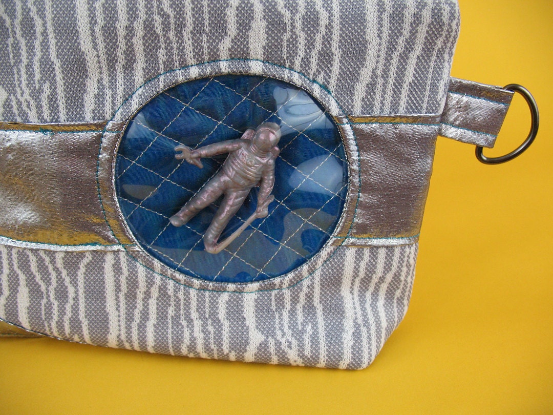 silver & blue-green Spaceman clutch - window with toy inside
