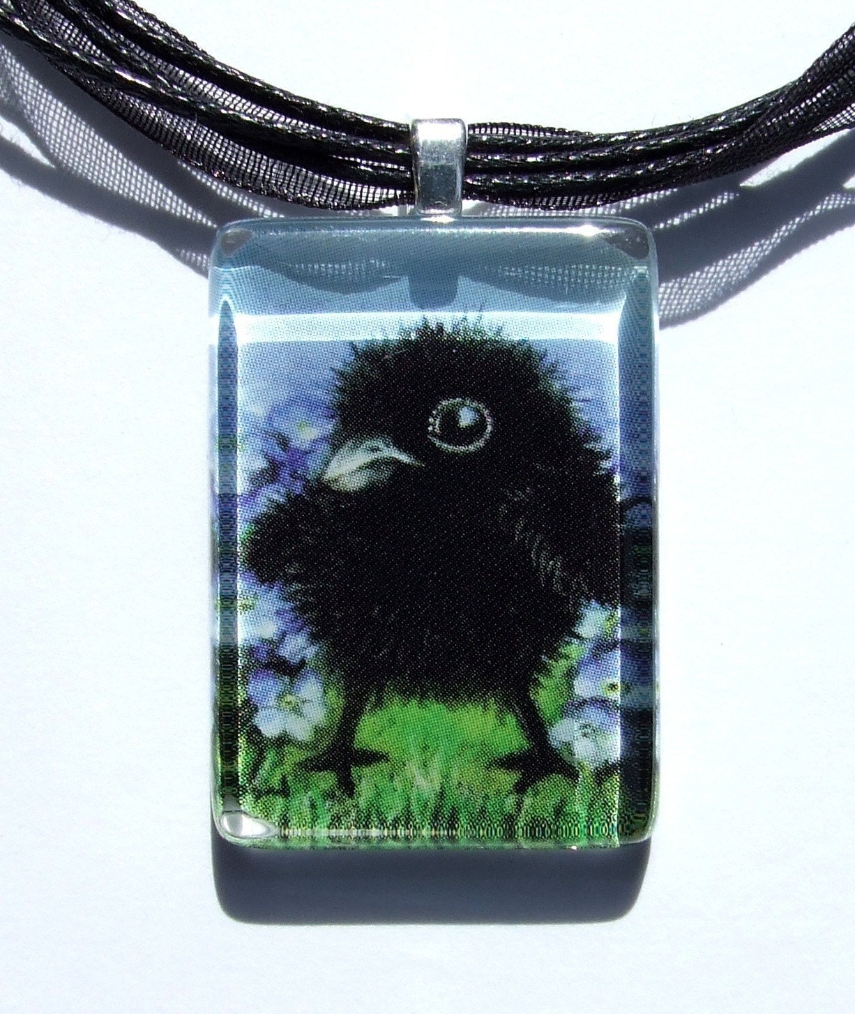 Baby raven among forget-me-nots - glass tile pendant - wearable art necklace featuring print of painting by Tanya Bond