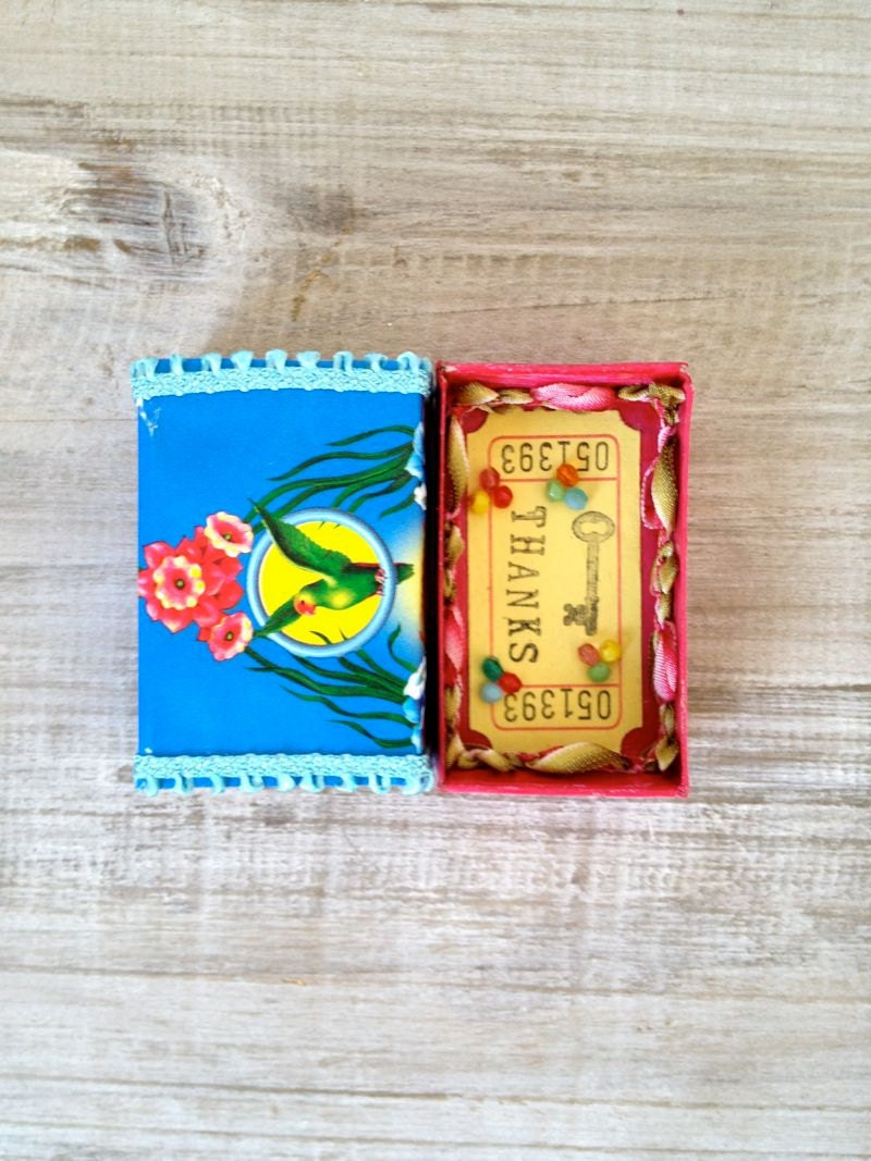 Altered vintage matchbox with a tropical bright greeting inside