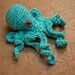 turquoise silk crocheted octopus with red eyes