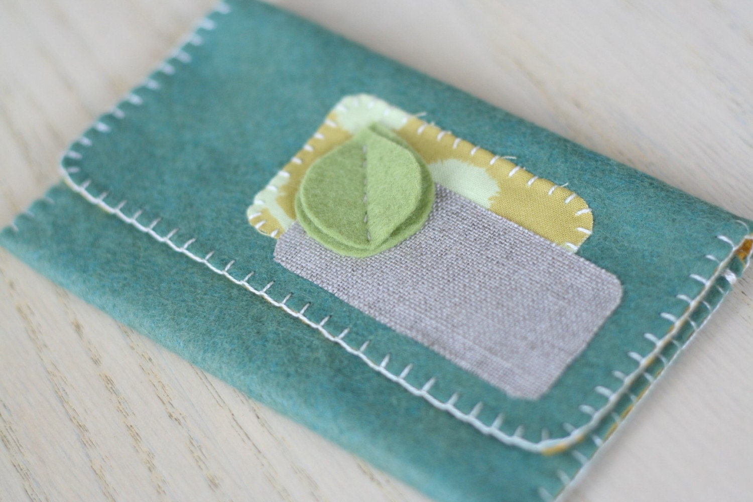 leafy felt wallet, teal with green leaves.
