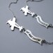 Message in the Sky - silver airplane statement necklace with banner