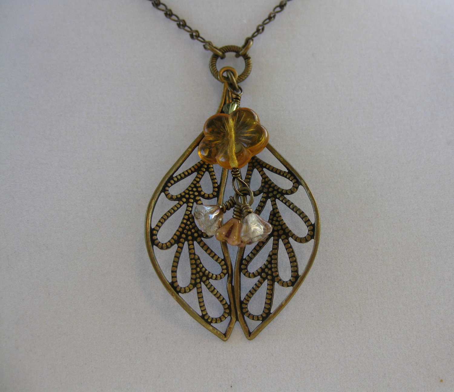 Cascading flowers on a filigree in brass ox necklace