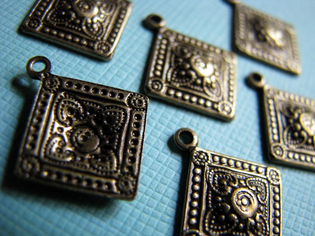 6 diamond-shaped brass drops