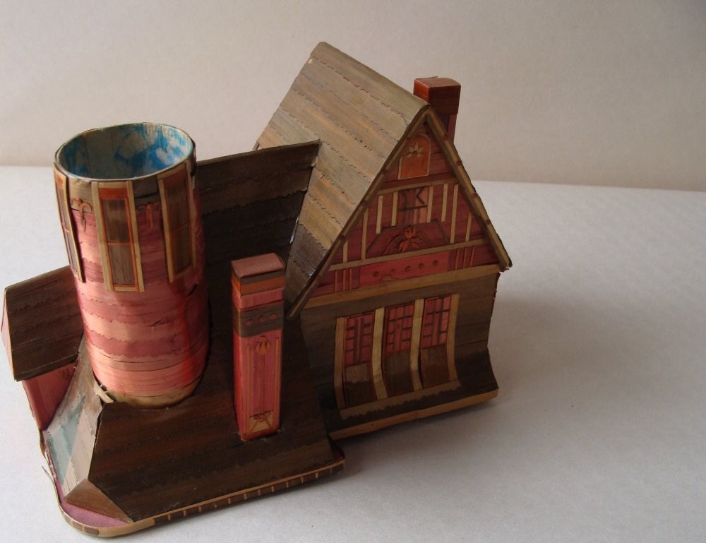 an intricate chalet made of grasses and paper probably made in germany and probably a candy box