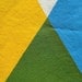 hand screen printed tea towel. blue and yellow makes green triangles.