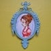 Tiny watercolor illustration in an aqua metal frame