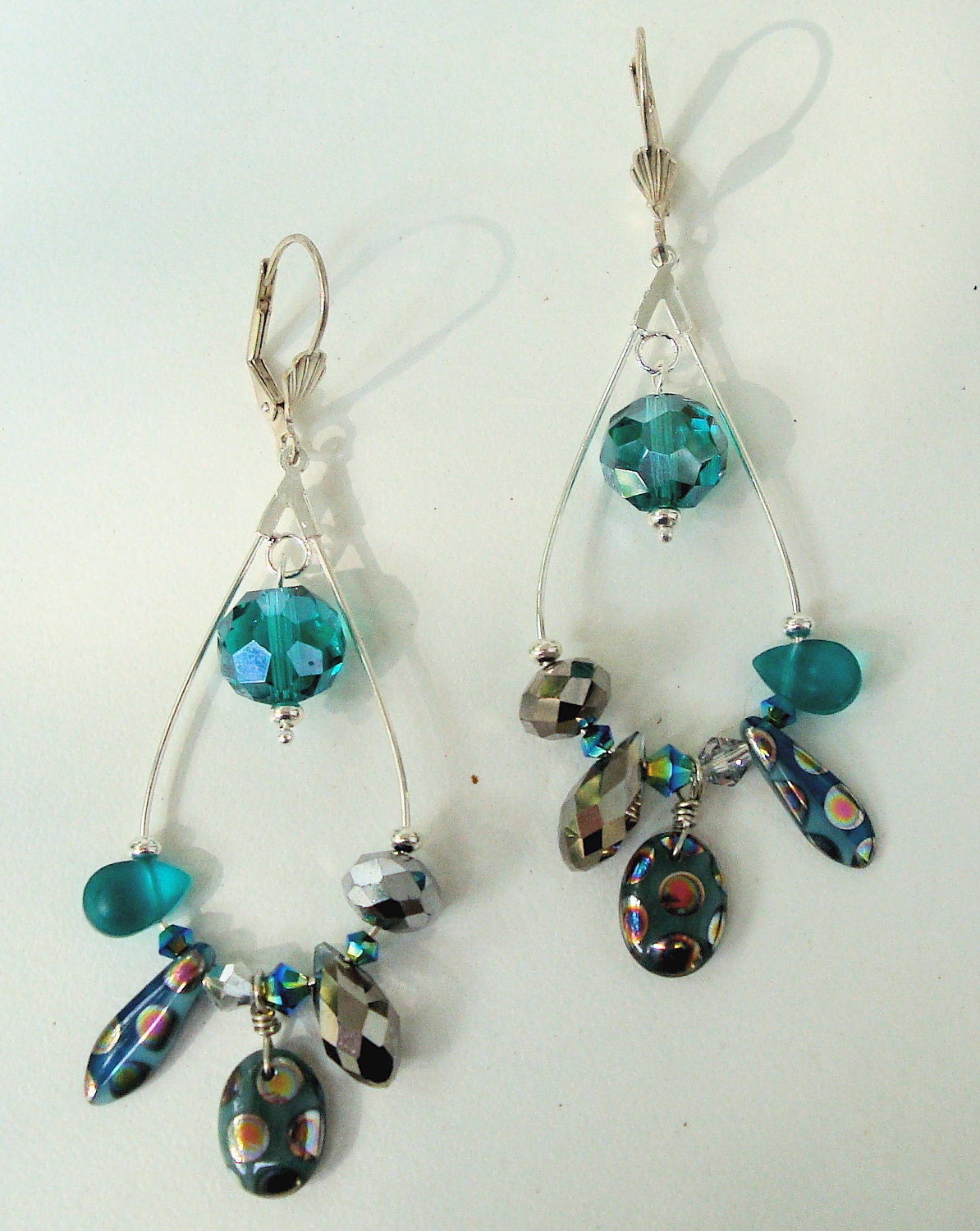 Gold tone elongated hoop earrings with multi color crystals and glass beads