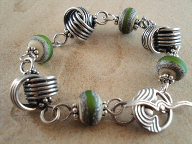 Sterling silver love knot and lampwork bracelet. Green glass beads. Etched. Fancy toggle clasp