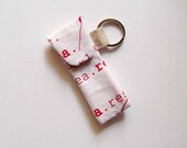 lip balm or usb stick holder keyring. red text on white