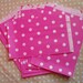 Set of 100 pink paper bags with white polka dots.