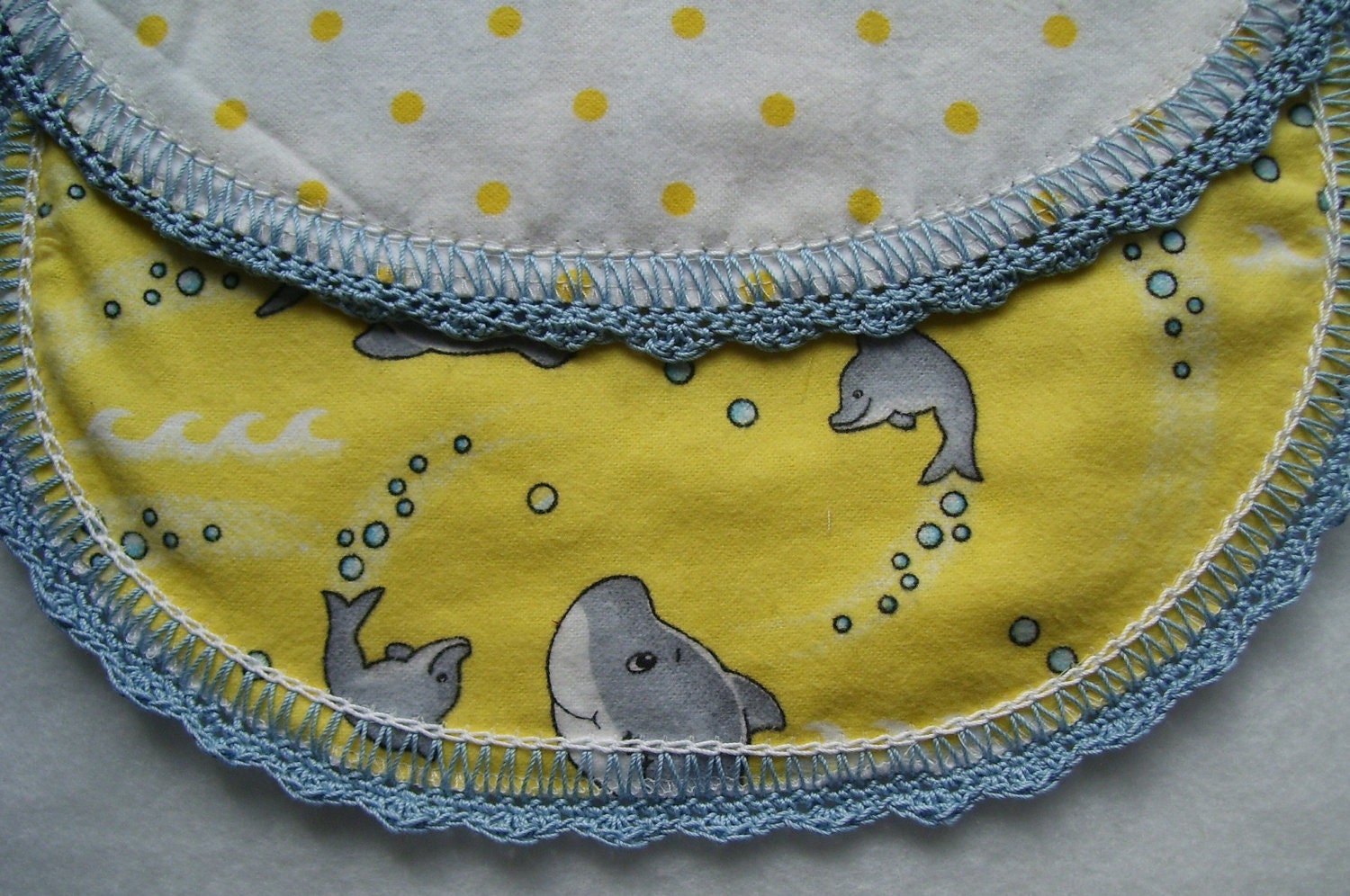 Baby Dolphin Burp Pad Cloth is handmade and perfect for the little person in your life made in the USA a blue hand crocheted edge