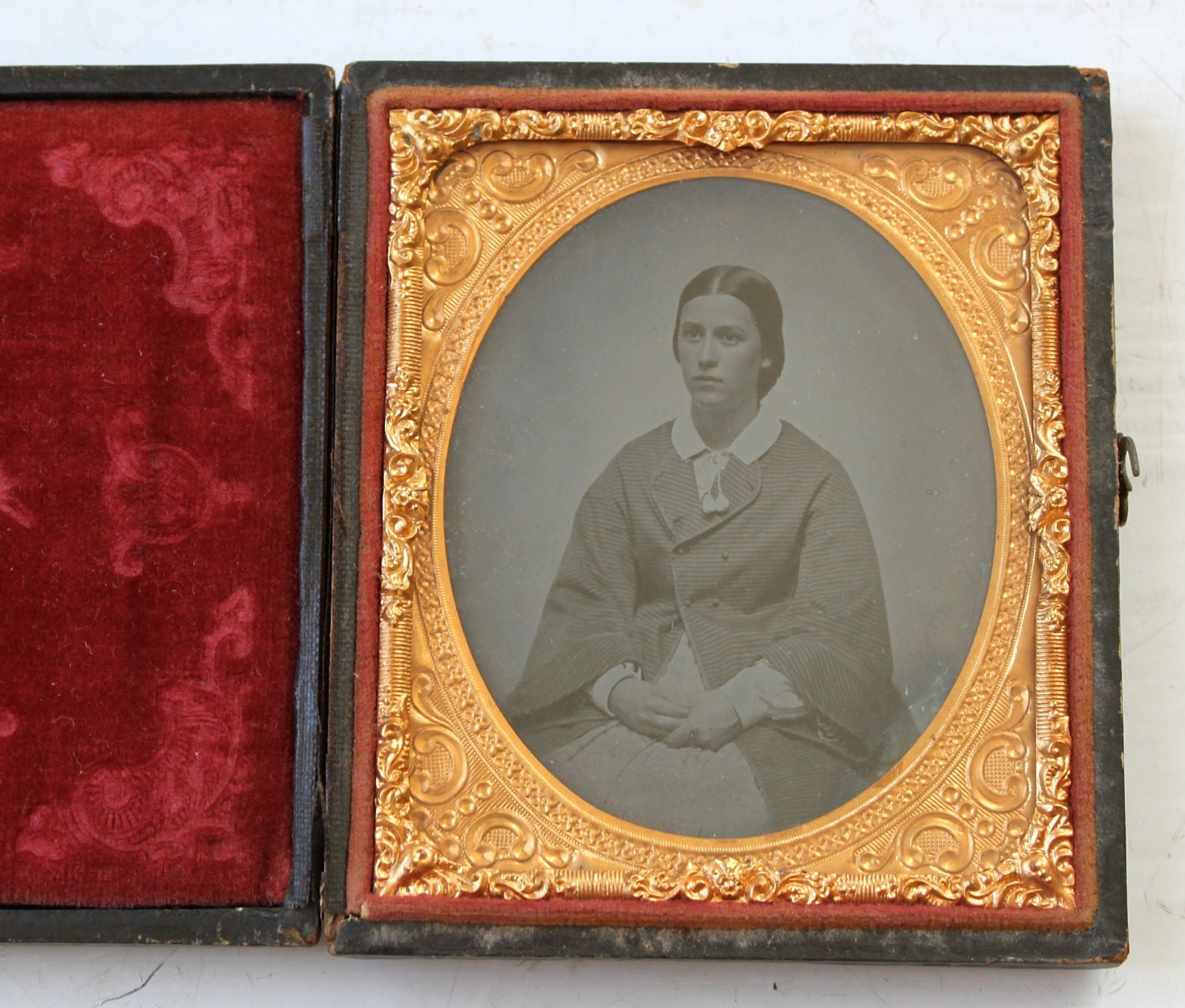 antique 1850s ambrotype. sixth plate. leather case. young woman in fancy coat.