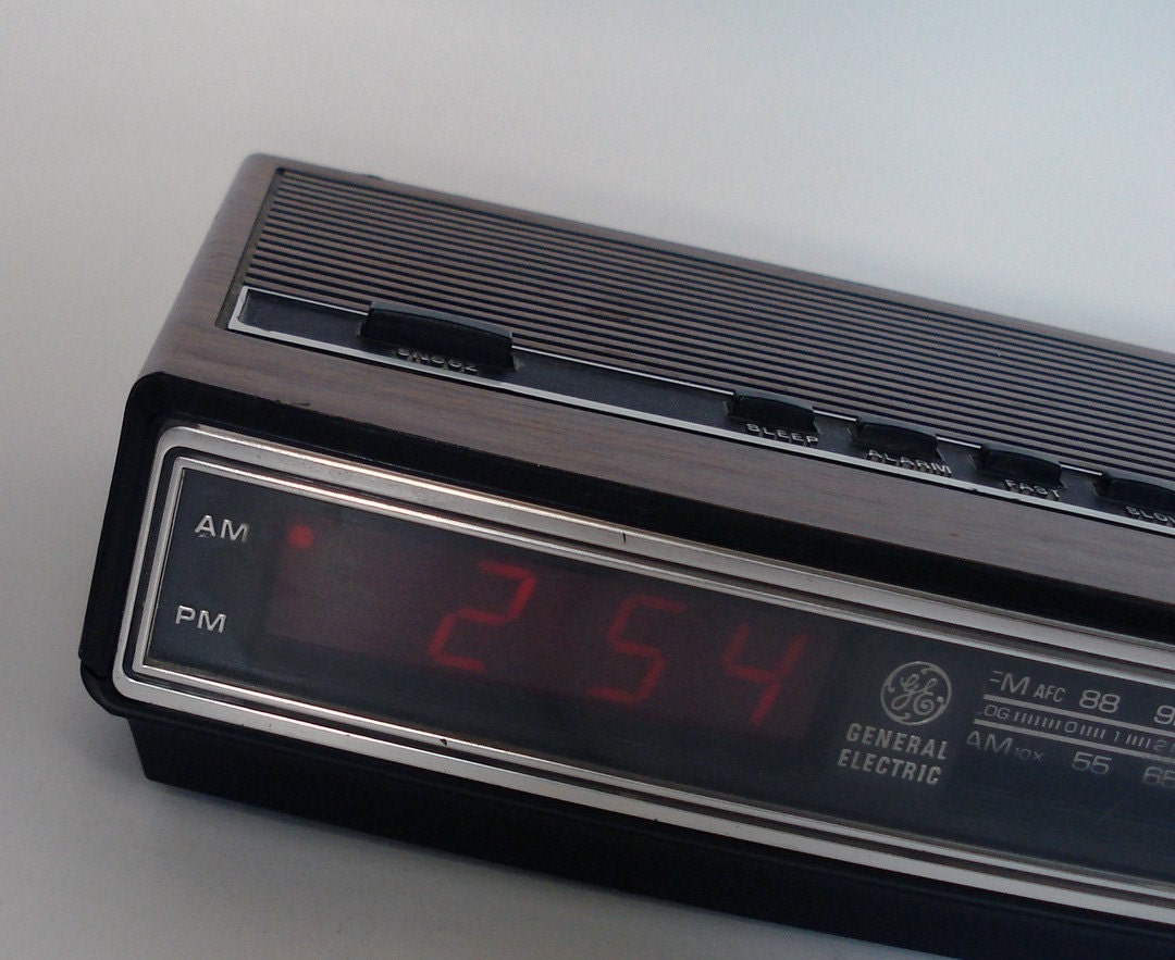 Vintage 1970s General Electric alarm clock with red digital numbers and woodgrain exterior