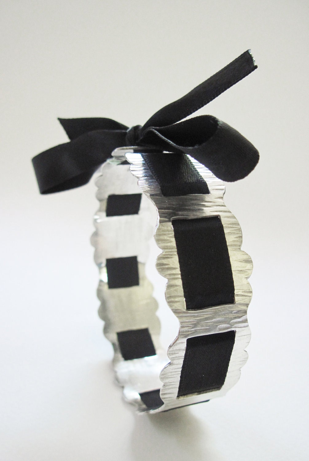 Sterling silver bangle with black satin ribbon woven through