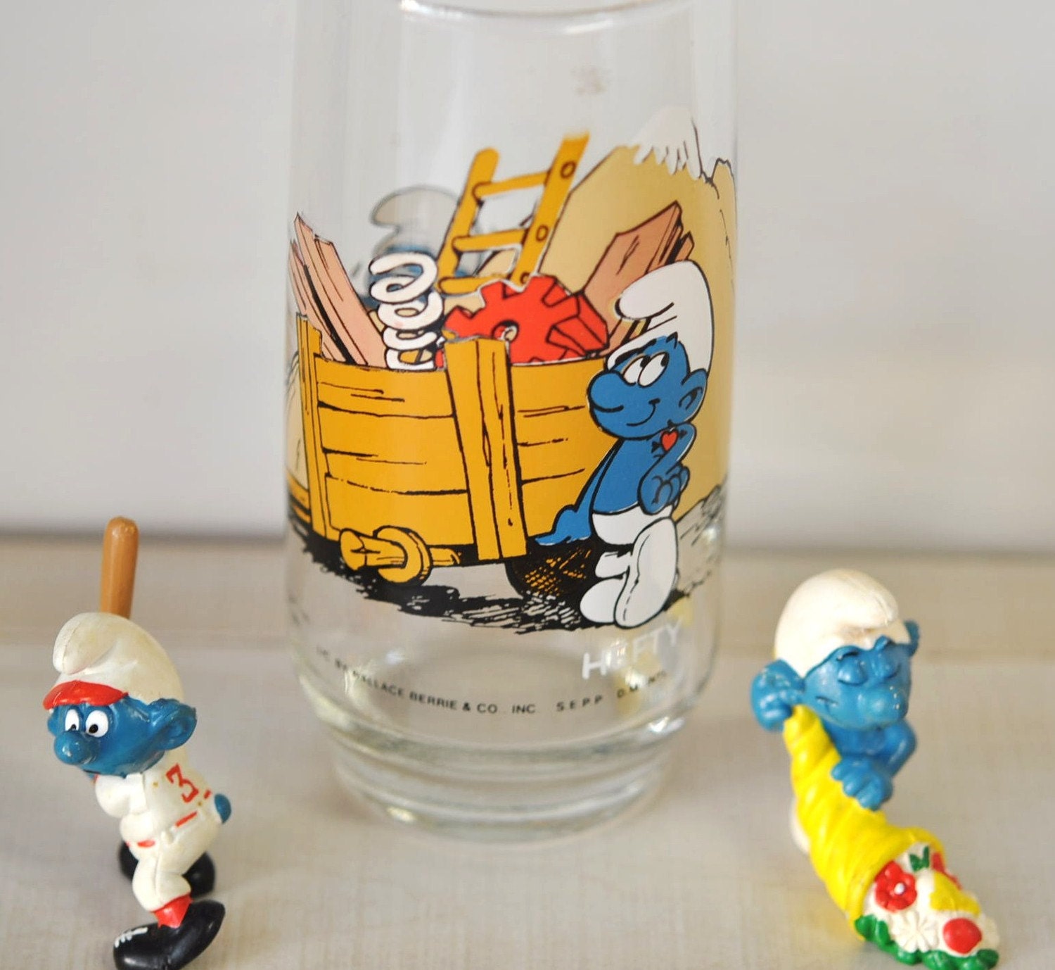 1980s smurf drinking glass with two smurf plastic fast food prize figurines--collectible