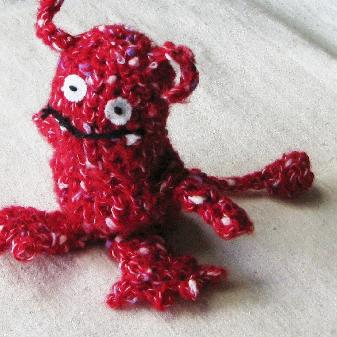 Red monster, crocheted from soft speckled red yarn, a little over 5 inches tall