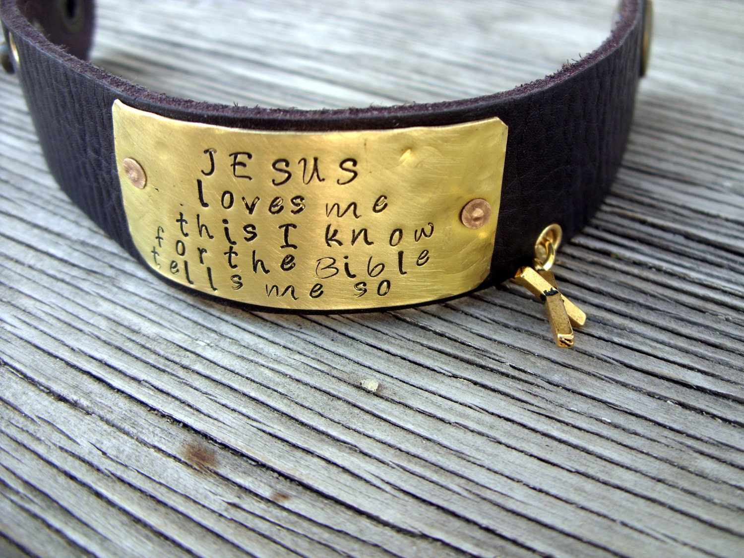 A riveted, brown leather cuff bracelet with hand stamped brass do small things with great love- distressed and embellished wording