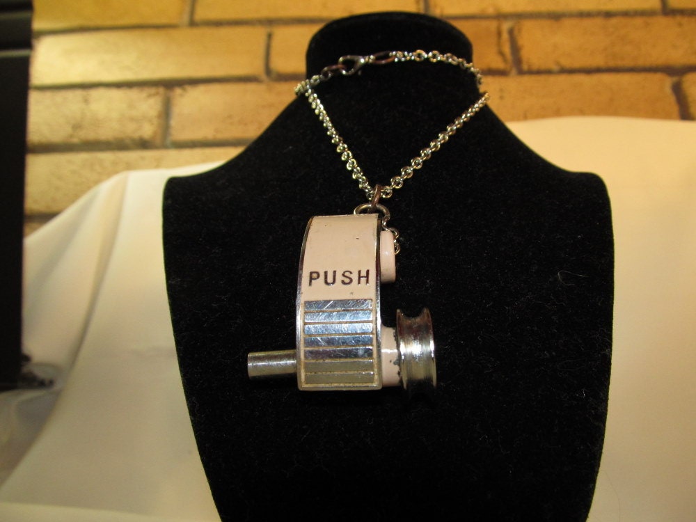 Steampunk "PUSH" bobbin winder part from a 1950s pink Atles sewing machine Necklace.
