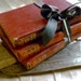 c1917 crumbly old books, black vintage ribbon and an antique key
