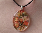 Summer  apricot colored Verbena behind Oval glass. Real flowers pressed.