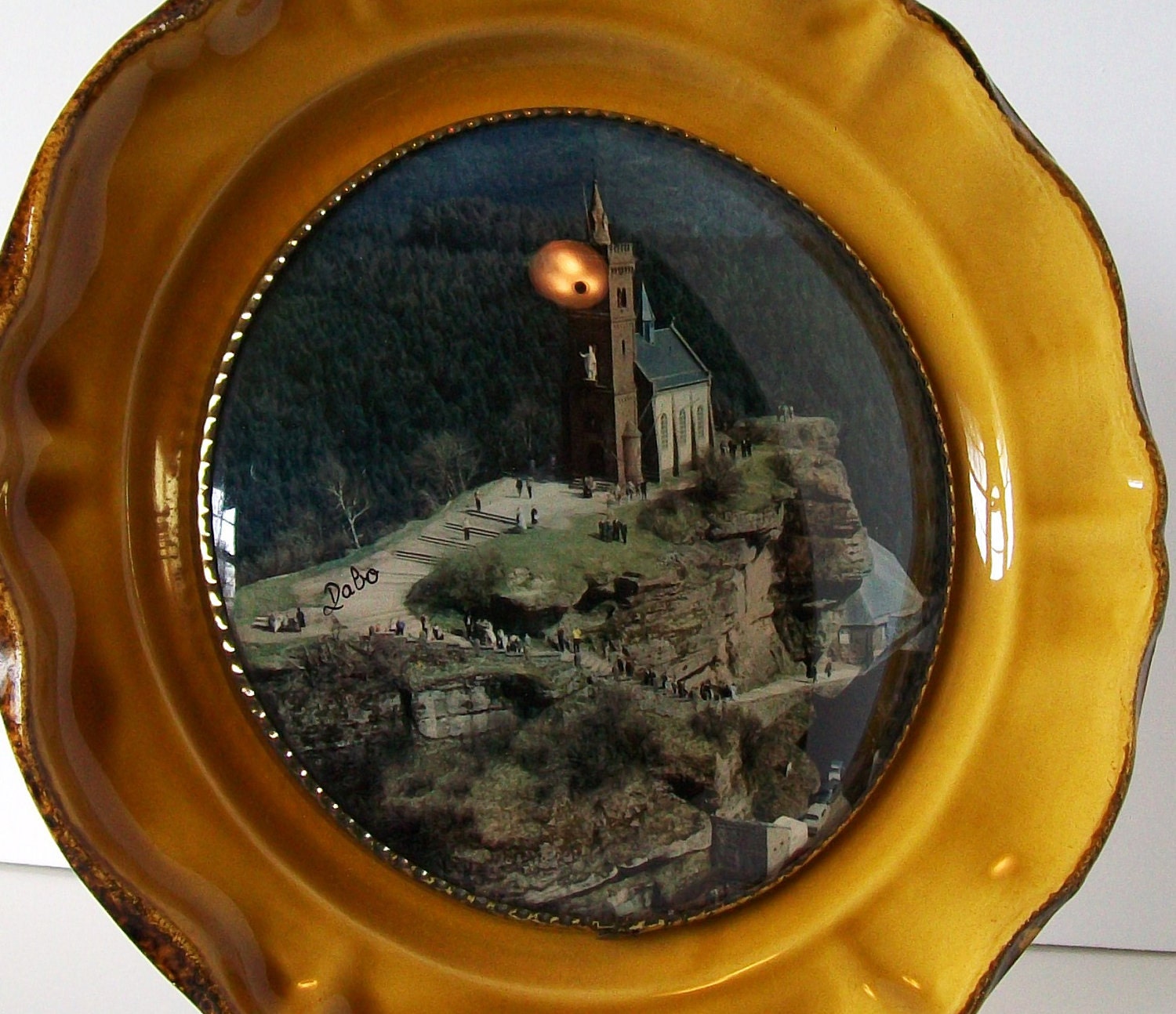 Hanging Decorative Plate with Domed Glass over Photograph of Church on Mountain Cliff