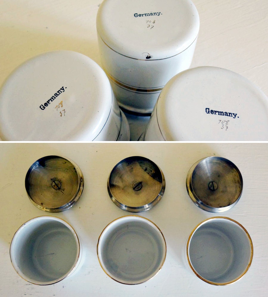 vintage enamelware canisters, 3 small tins with leather straps, white with gold striping from Germany