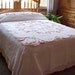 Soft pink and blue flowered Chenille bedspread on white