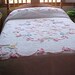 Soft pink and blue flowered Chenille bedspread on white