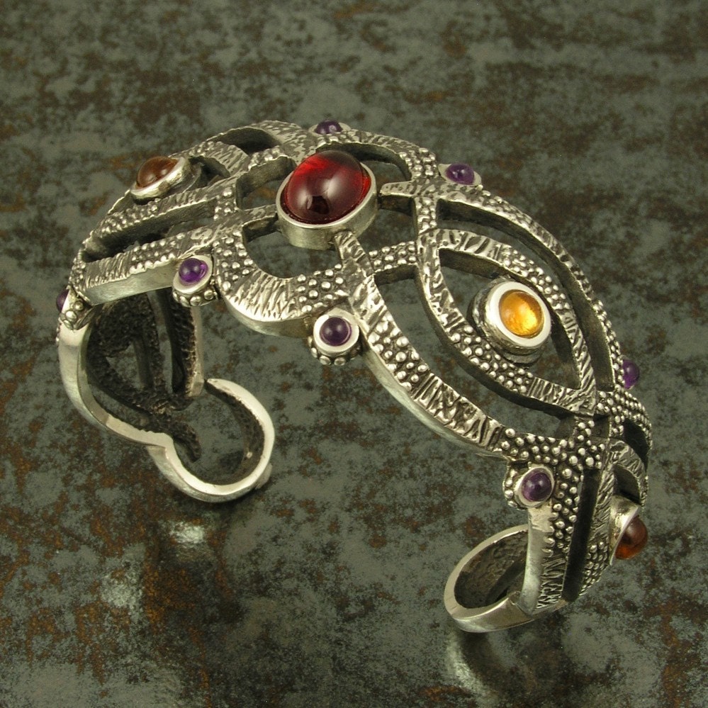 Sterling silver cuff bracelet with amethyst, garnet and citrine cabochons.
