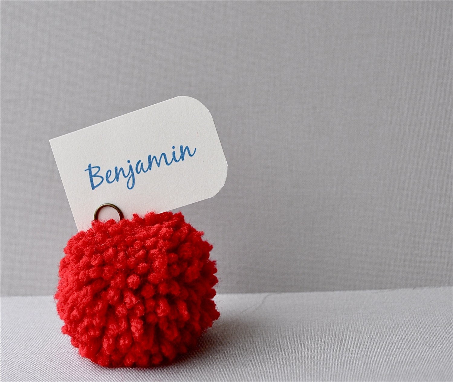Red yarn pom pom place holders.  Wedding decor, party favors, pom poms