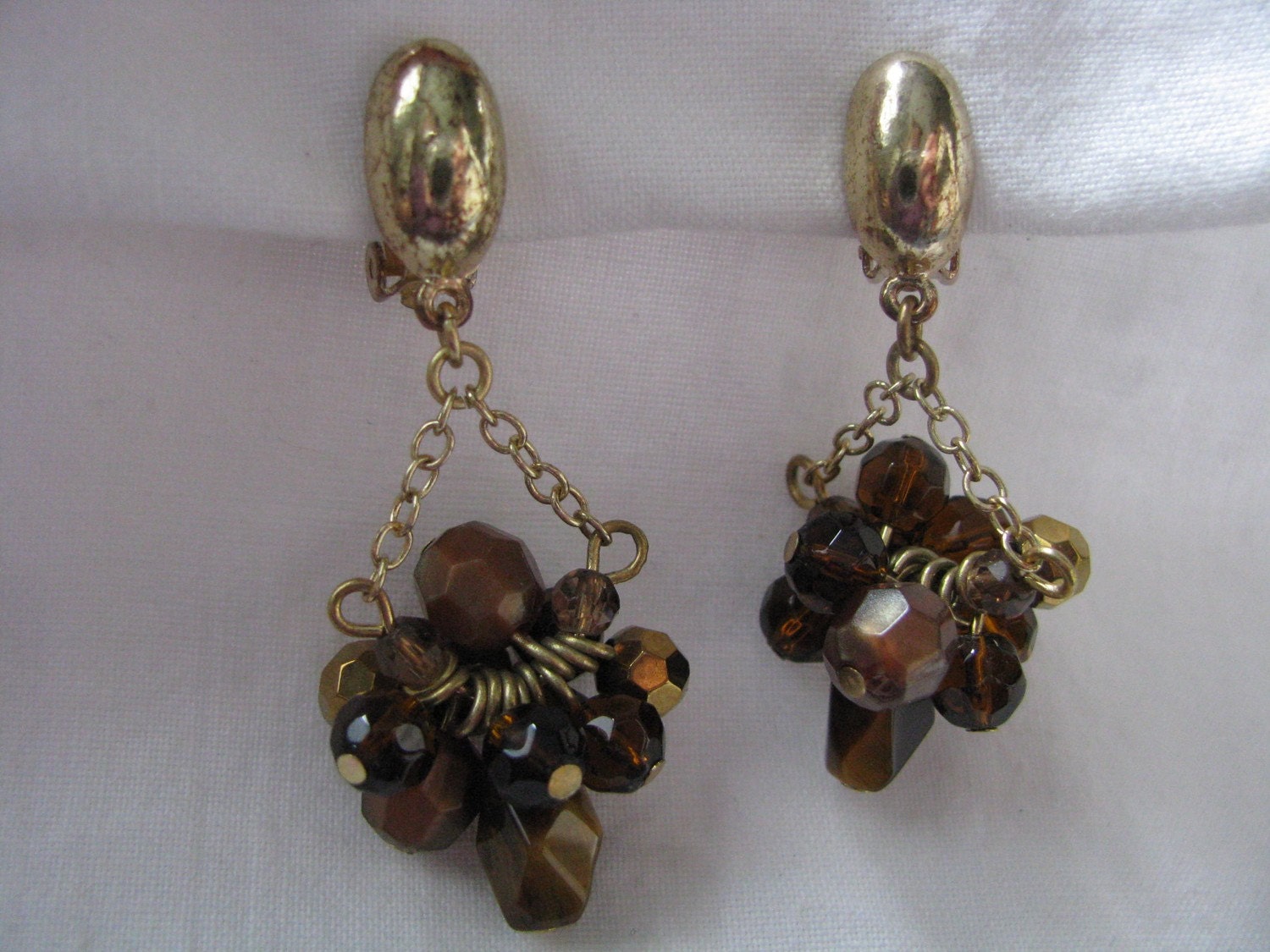 Gold tone dangle clip back earrings with brown faceted bead clusters. Clip ons.