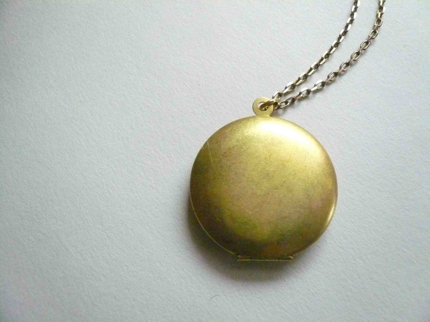 Vintage gold locket on long necklace chain. Simple and romantic brass circle locket.