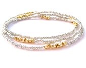 she's electric // bracelet / necklace with mini geometric gold beads on background of silver seed beads