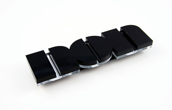 Non brooch in black perspex