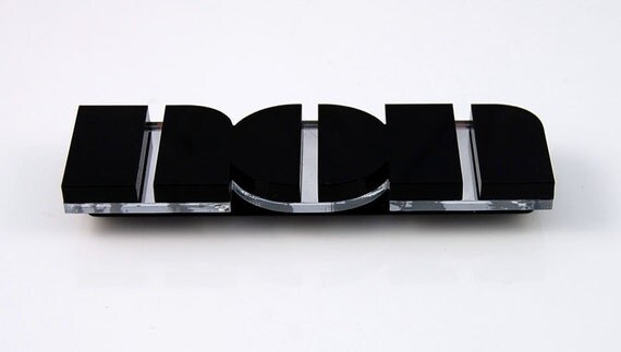 Non brooch in black perspex
