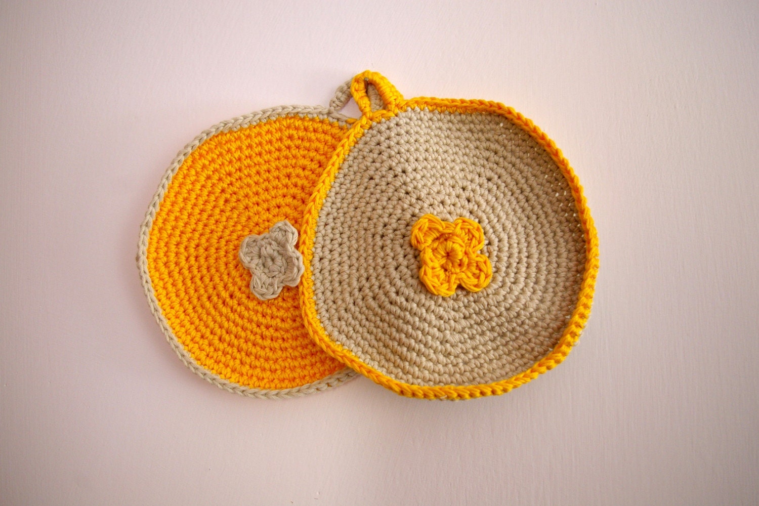 Crocheted pot holder with crocheted flower