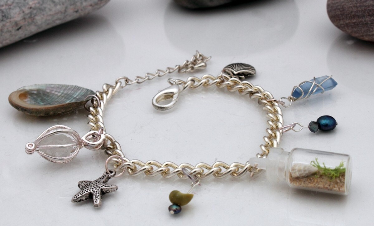 Beach themed charm bracelet with miniature beach in a bottle, sea glass and pearl charms