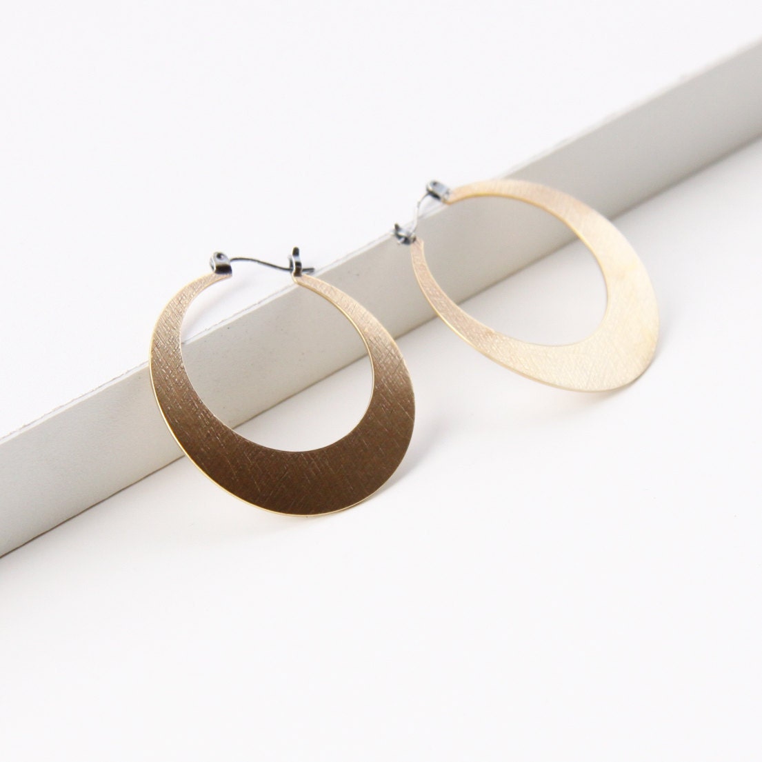 Sleek hoop earrings handmade with embossed brass and flip flop type silver earwires, comfortable and lightweight - "Lunar Hoops in Brass"