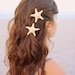Two small white knobby starfish barrettes.
