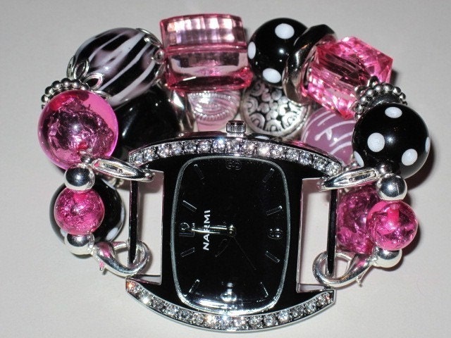 Chunky black and white polka dot, pink and silver interchangeable watch band. Black watch face with rhinestones included