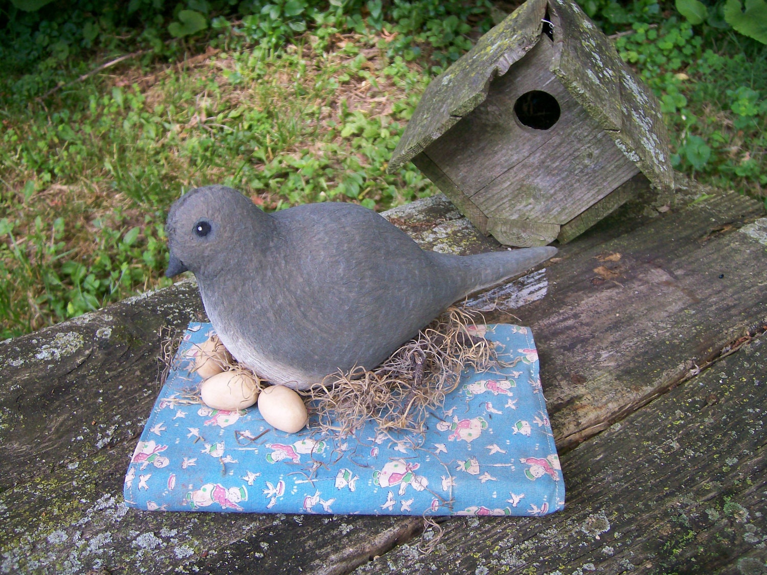 Primitive Folk Art Mama Dove and her Eggs resting on an old covered book nest