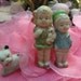 Vintage Bisque Dolls and dog, She is in a green dress with a red bow in hair ,holding a toy, He is wearing a green hat with blue shirt holding a book extra cute two hand painted marked Japan dolly pair boy girl plus a sitting dog c1950 Free Shipping