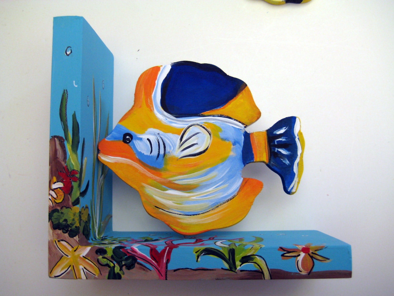 A hand painted wooden fish bookend customized to match an under the sea theme