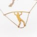 man walking on a wire golden necklace
