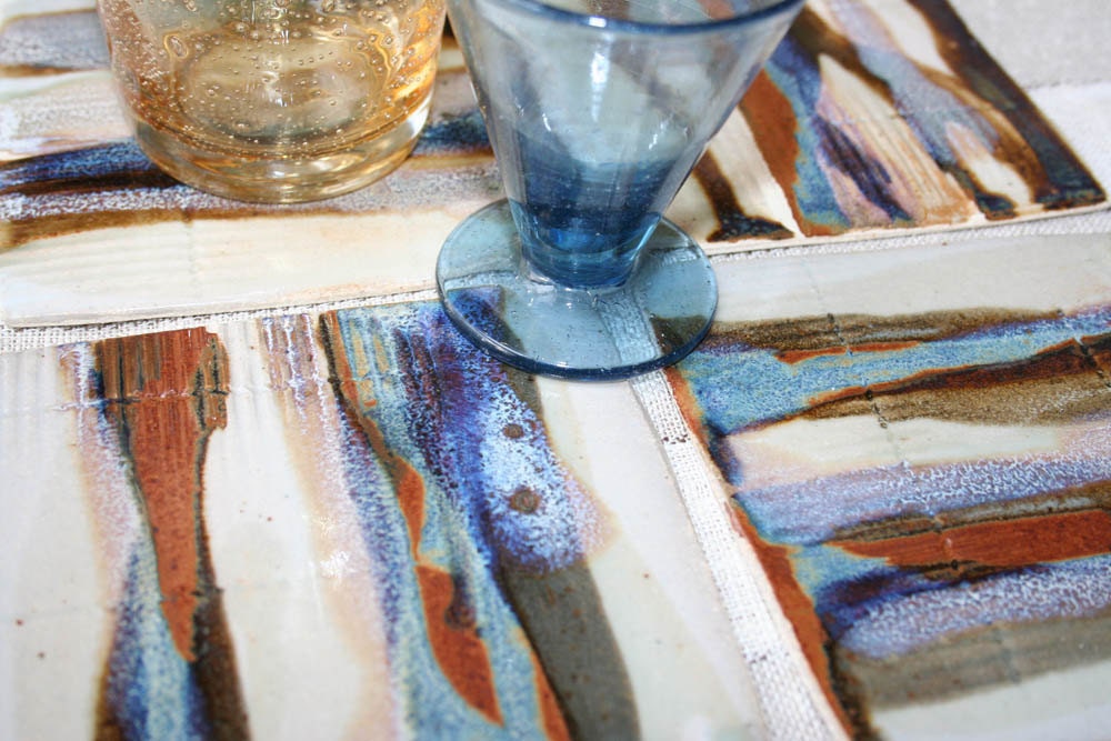 Set of four stoneware coasters with poured multicolored glaze treatment