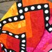 Quilt--Hot Colors of Yellow, Orange, Red and Pink Form the Background for a Black Maze with White Appliqued Circles