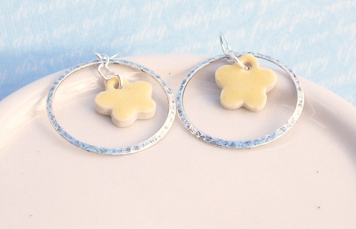 Silver hoop earrings with yellow clay flower